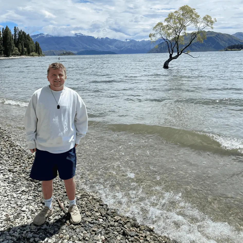 Henry stands next to tree in Wanaka