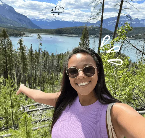 Issey stands in front of the Canadian landscape and takes a selfie
