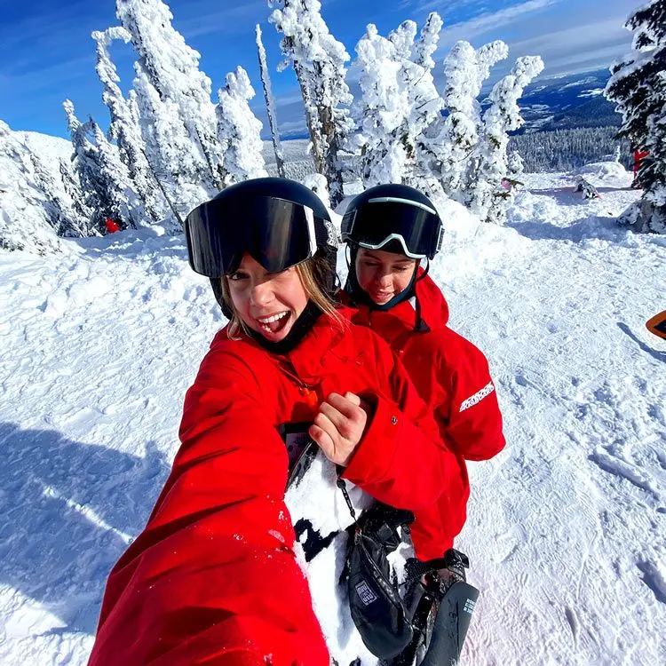 2 girls take selfie in the snow wearing red