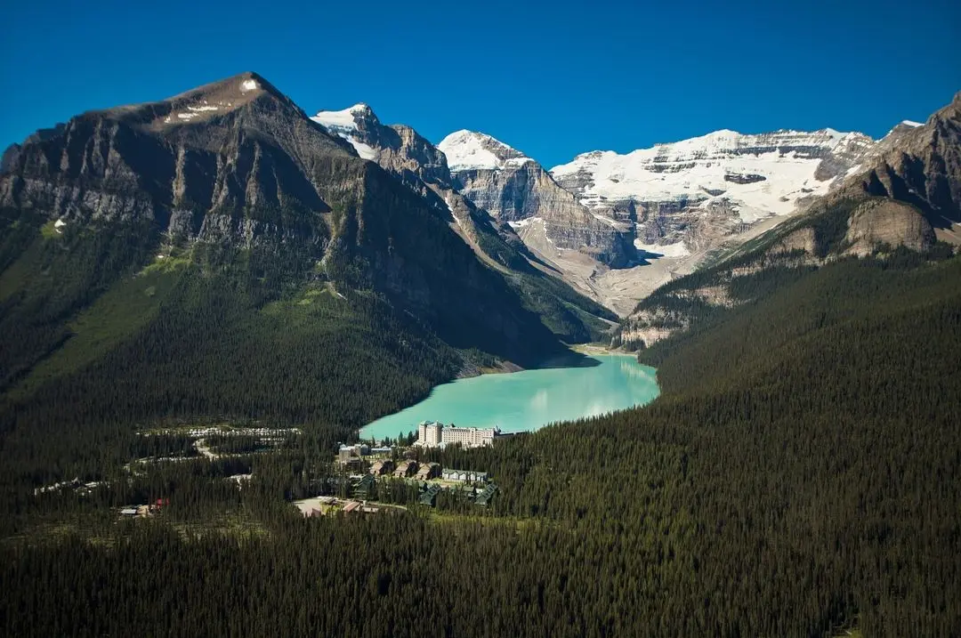 Aerial view of Fairmont hotel on edge of turquoise lake in forest