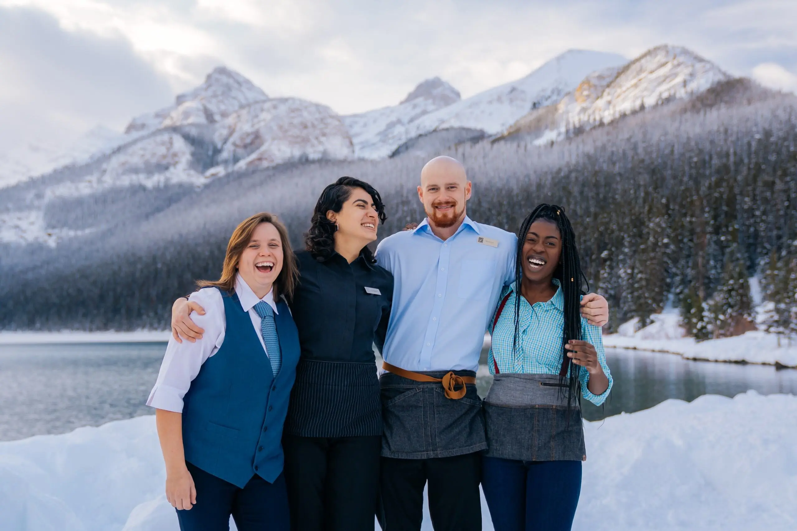 4 people stand in front of Lake Louise