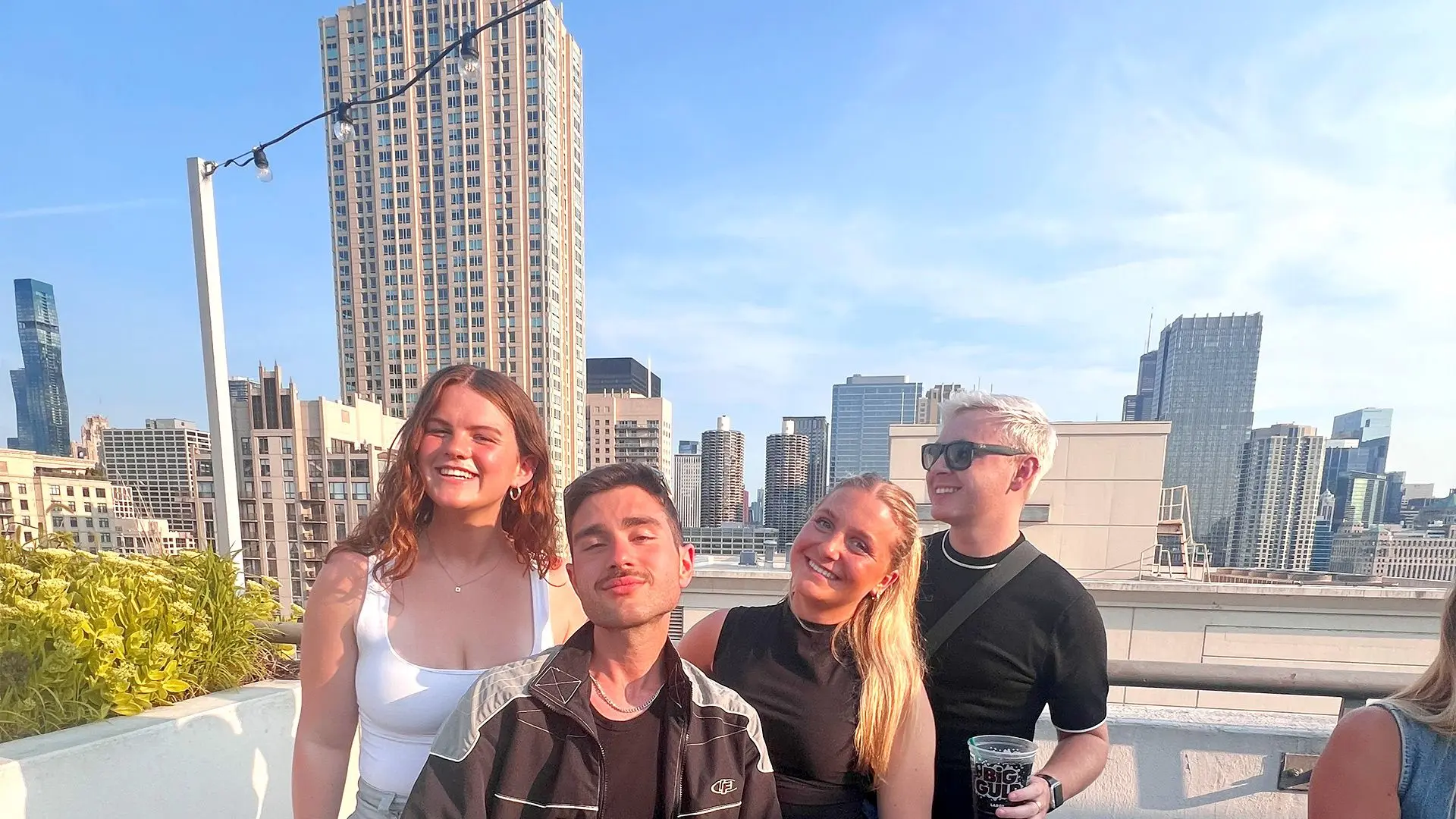 2 guys and 2 girls smile for a pic on a rooftop