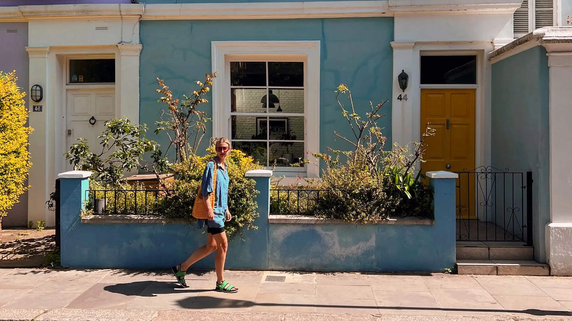 Girl walks in front of colourful houses