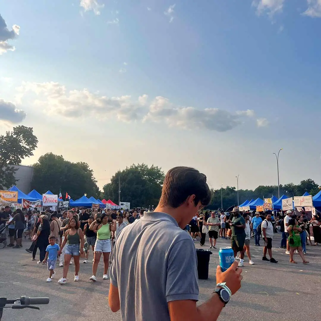 Guy walks through fair on sunny eve