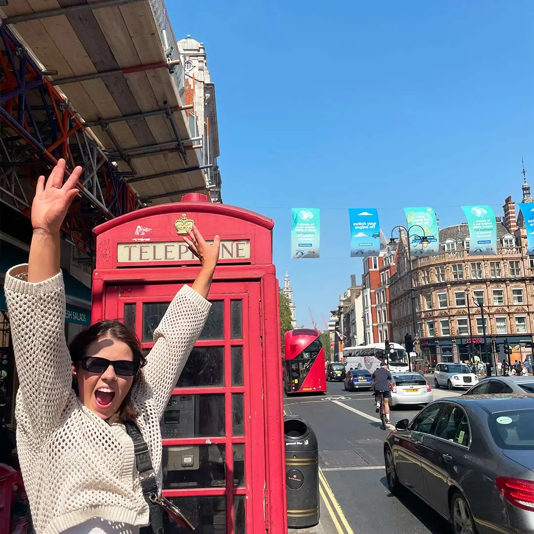 Girl poses in front of phone box