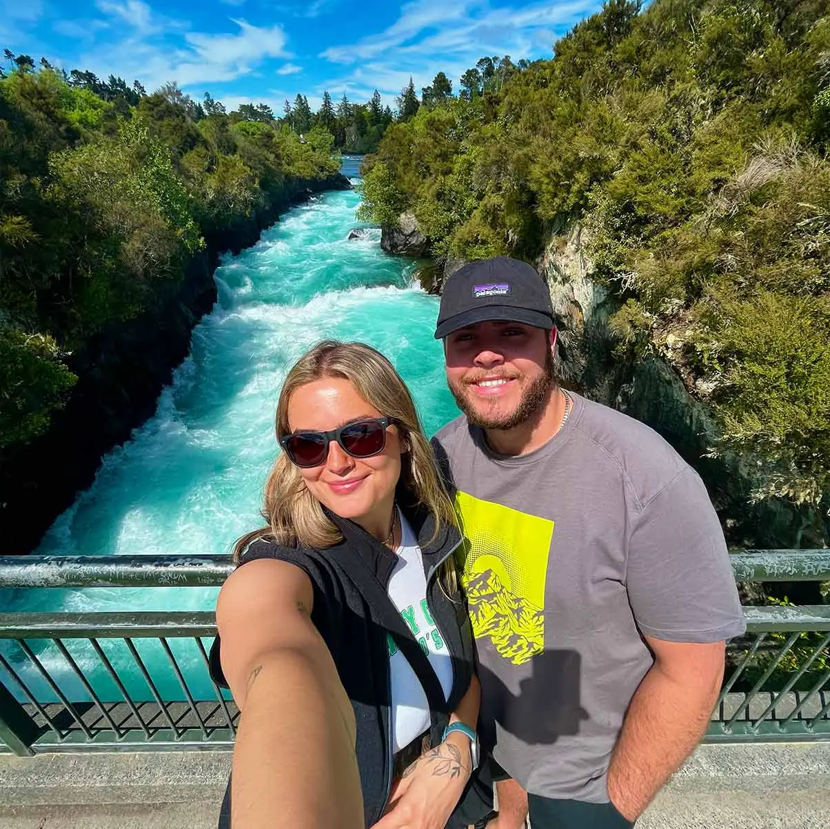 Couple stand on bridge over river