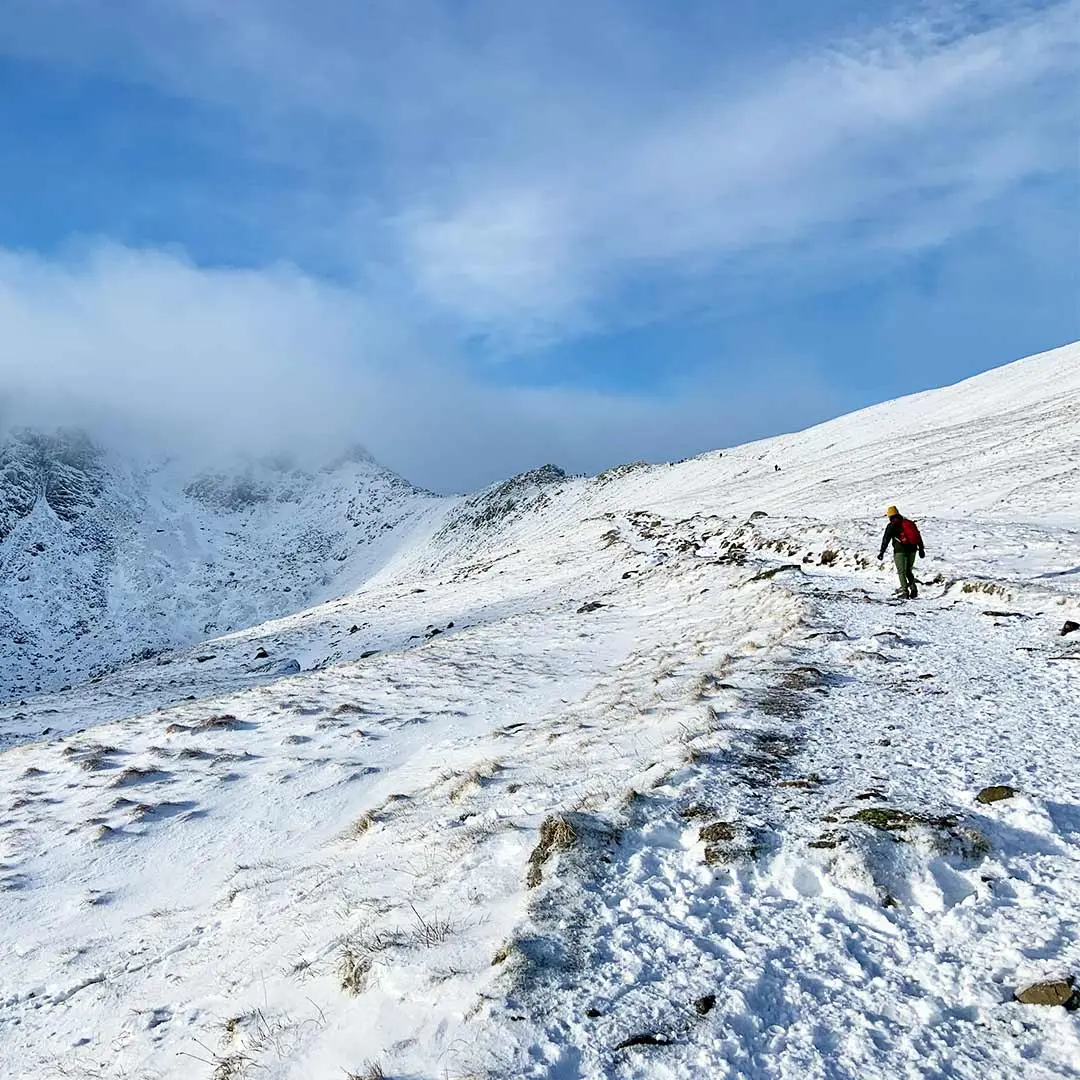 Man hikes up snowy mountain