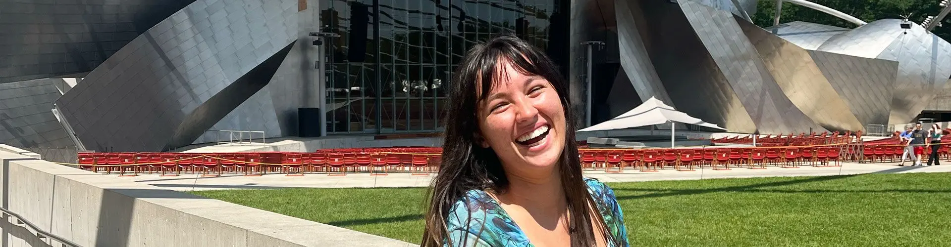 Girl smiles in front of monument in Chicago.