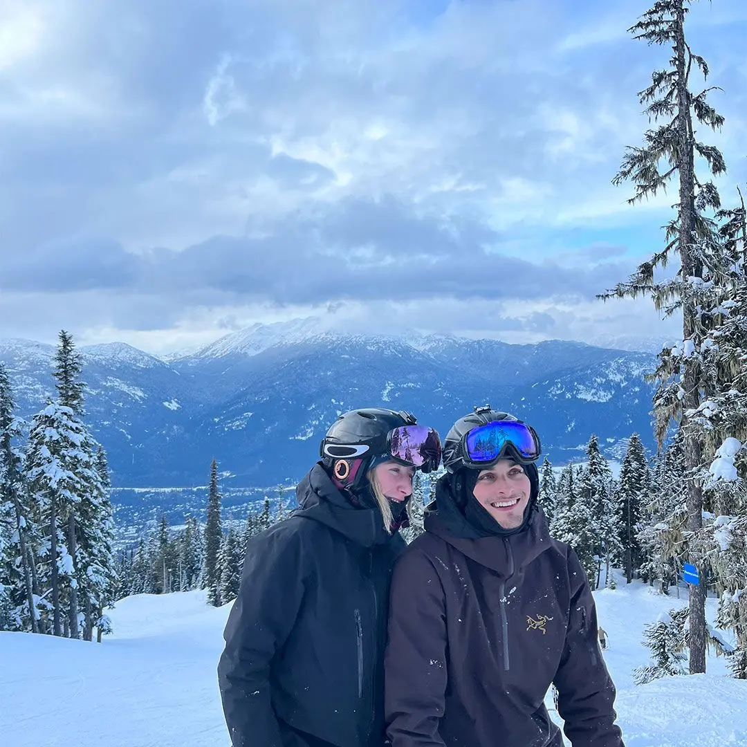 Guy and girl on snowy mountains in ski gear