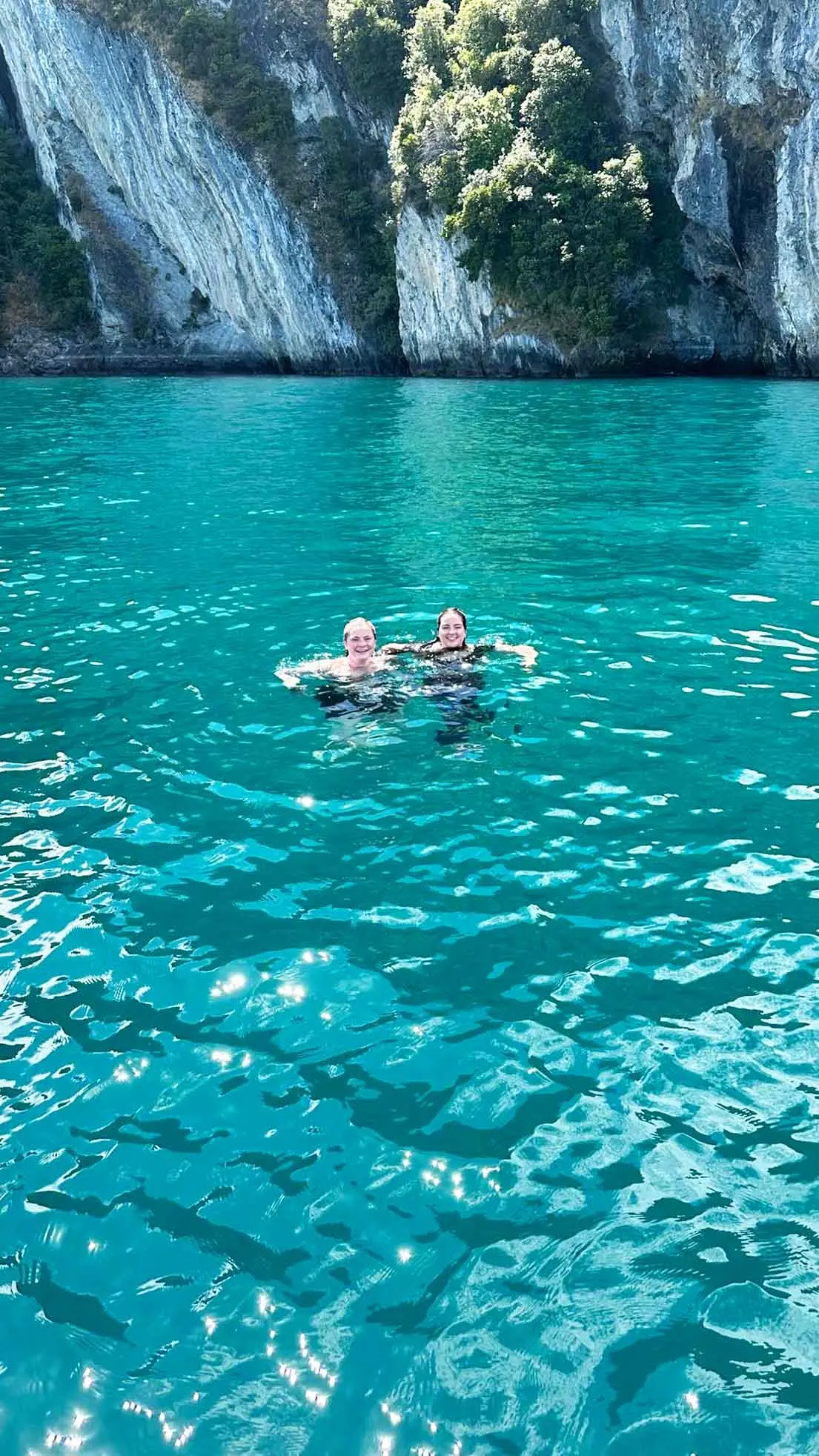 Girls float in turquoise water