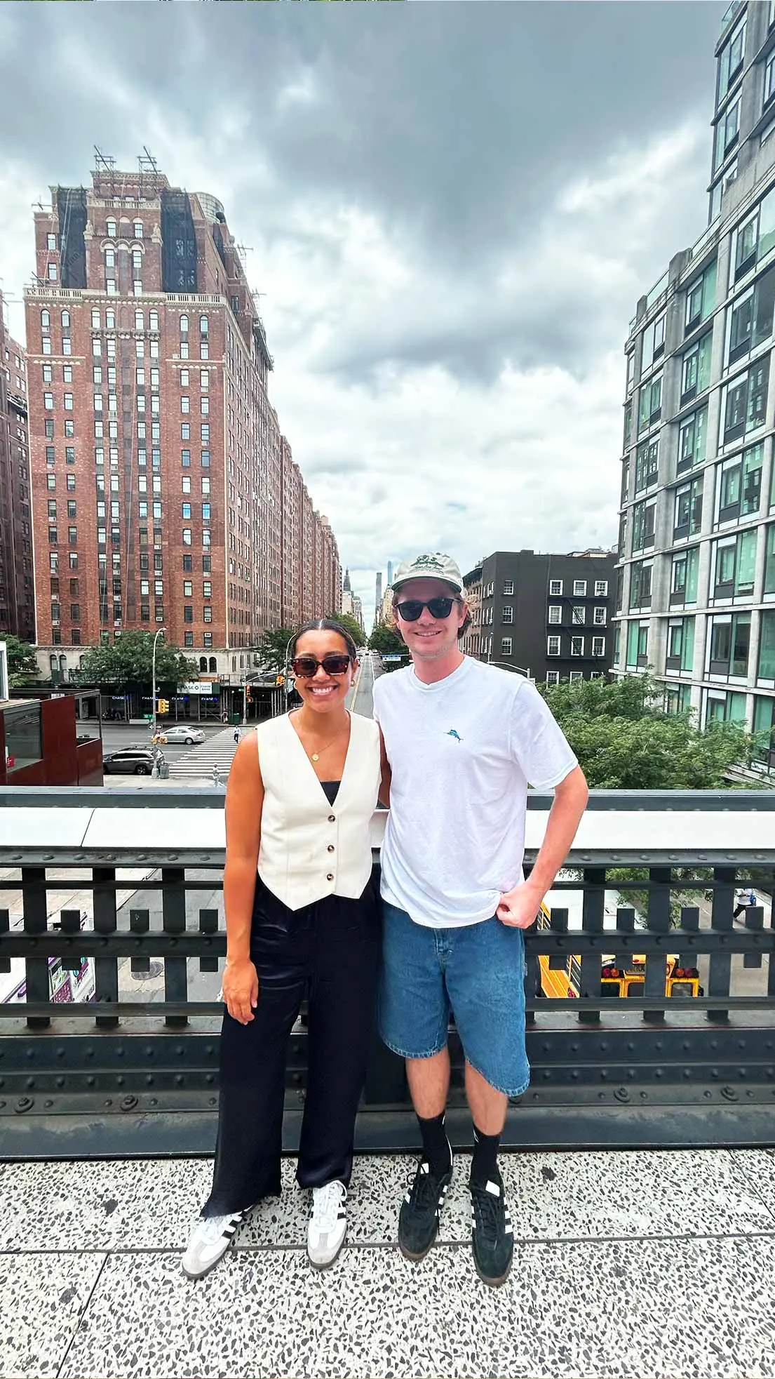 Guy and girl stand on bridge in NYC