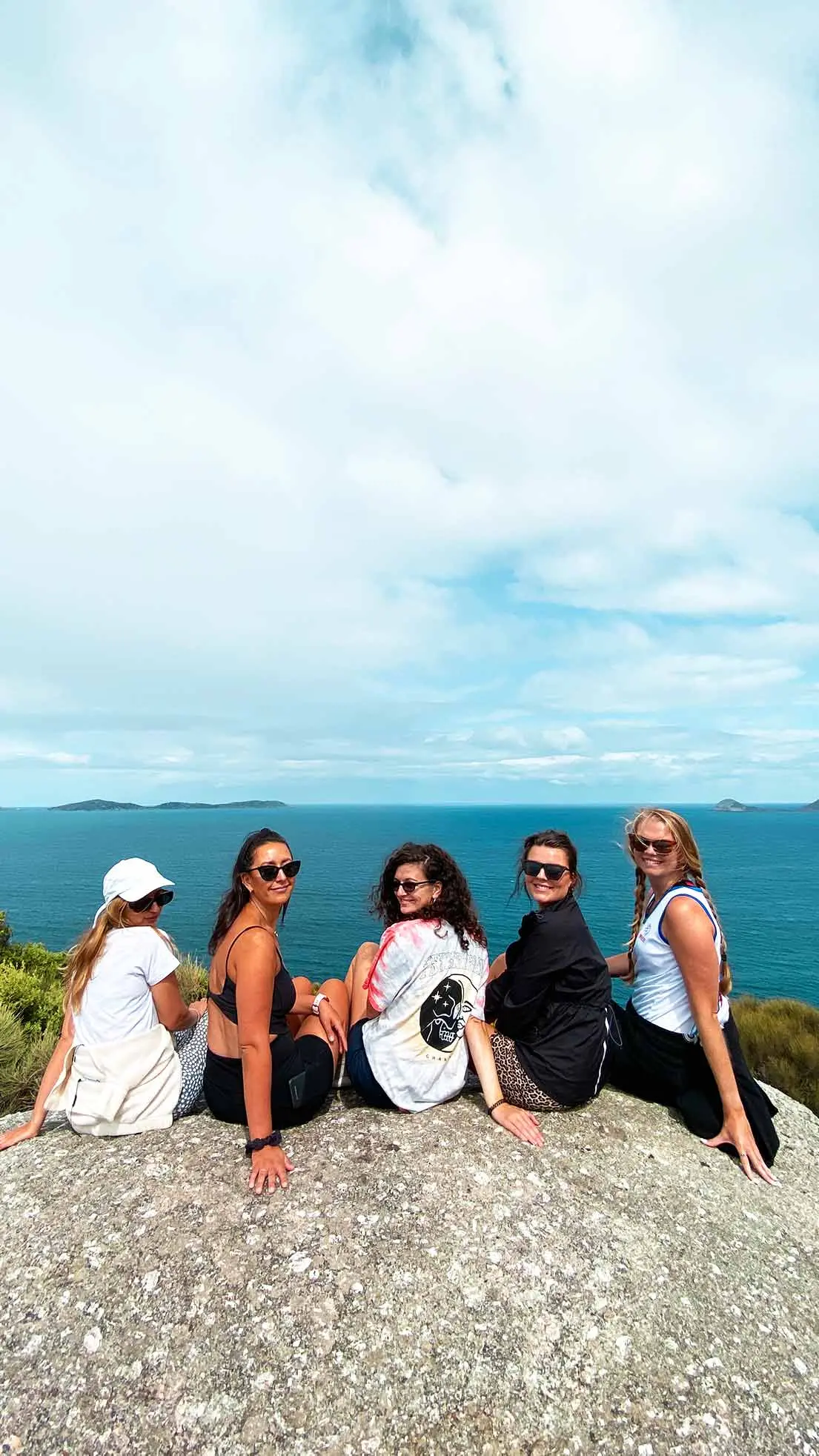 Friends look back at camera on rock