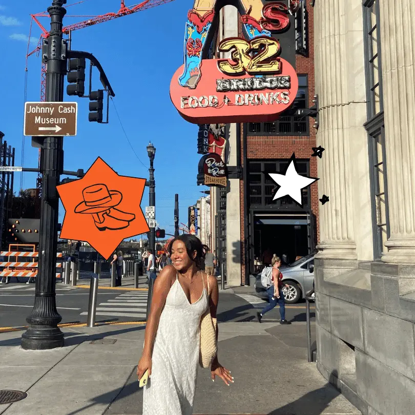 Girl walks down the streets of Nashville with Johnny Cash museum sign in the background.