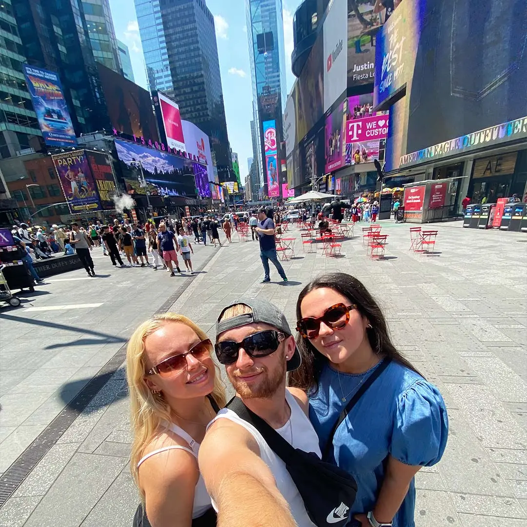 Guy and two girls on times square in NYC