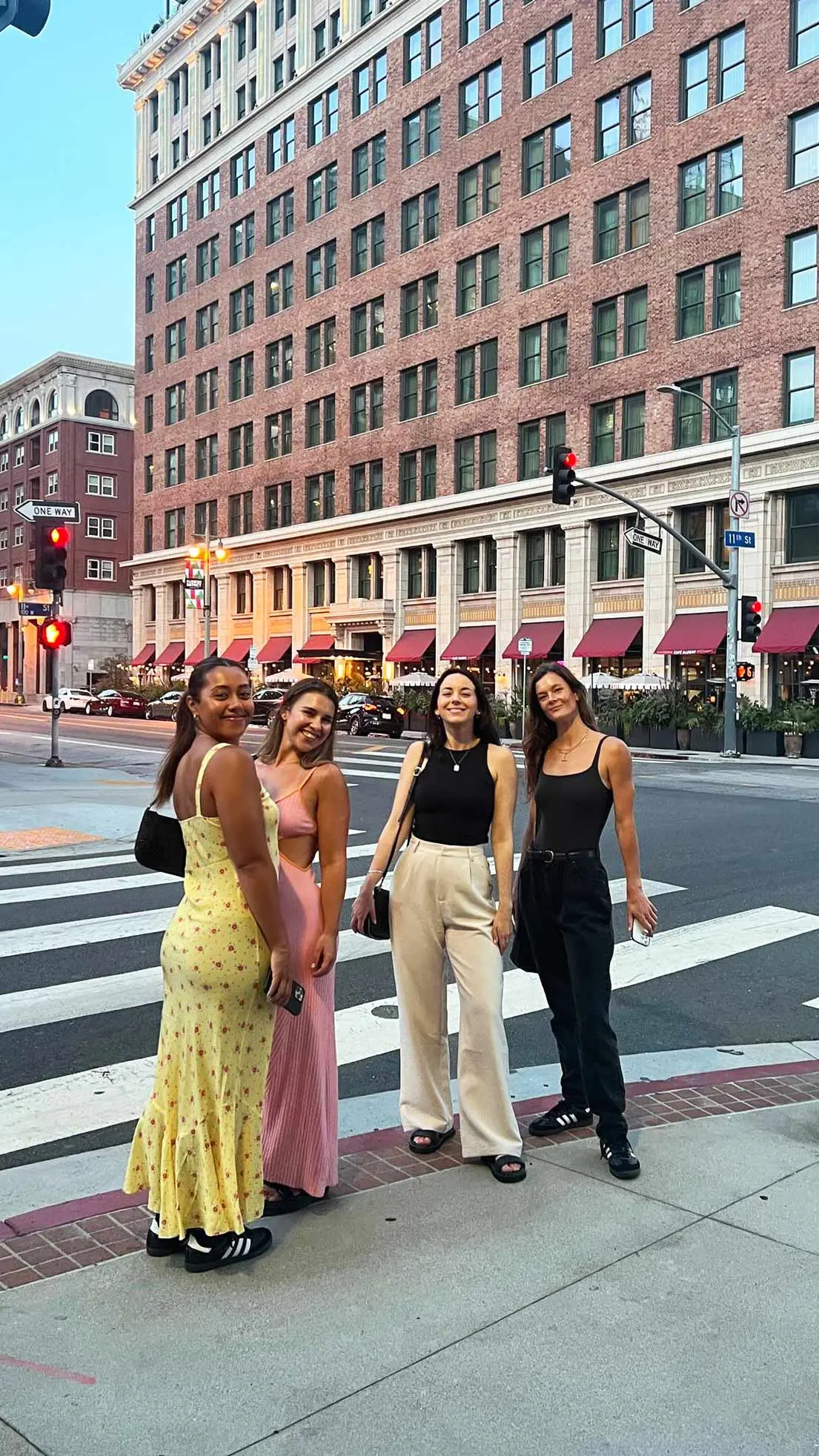 Four girls wait at traffic lights in NYC.