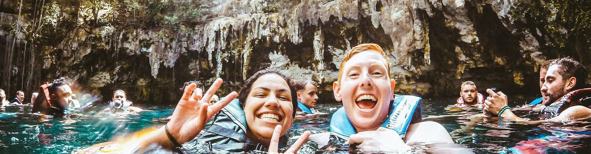 Guy and girl smile for camera in lagoon