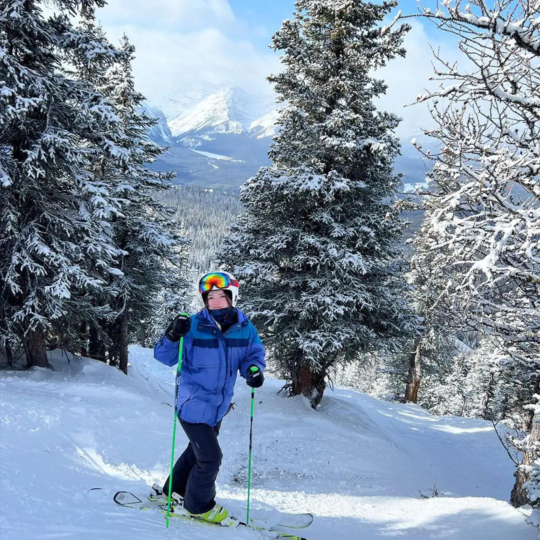 Girl skiing with trees and mountains