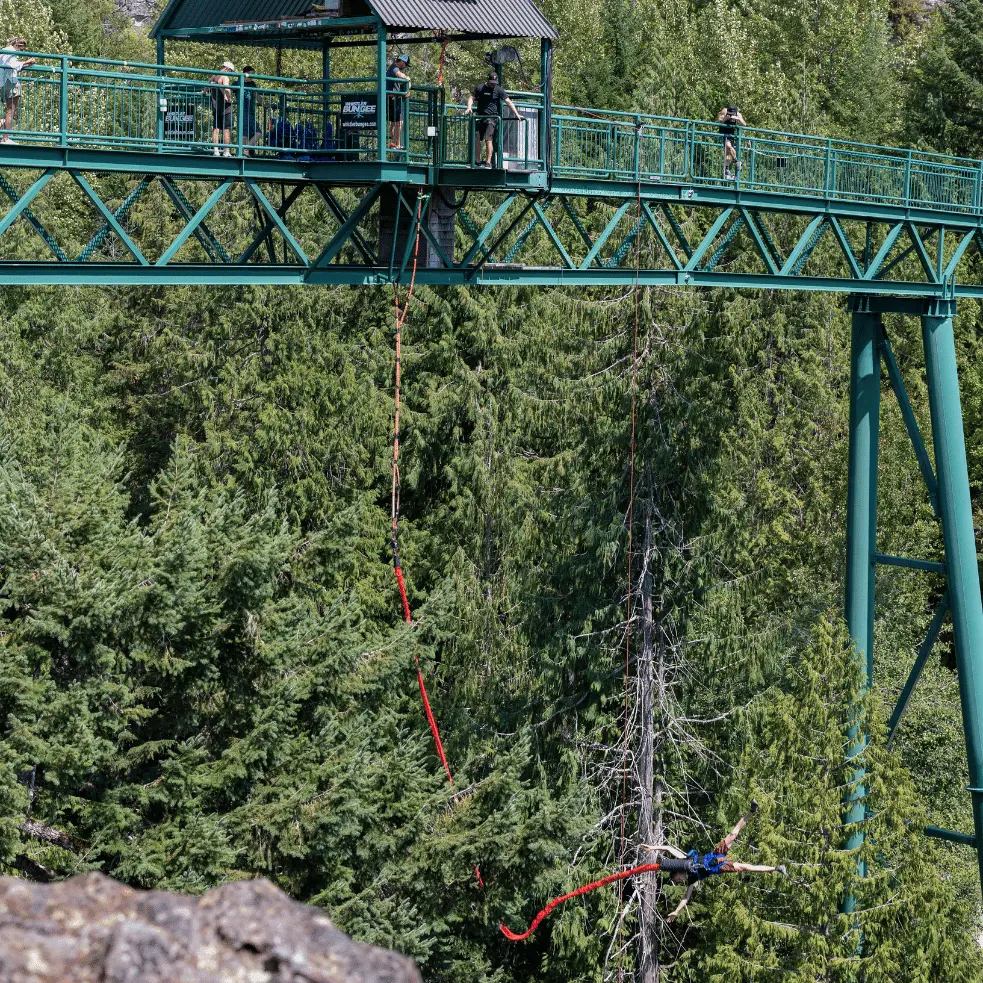 A person who is bungee jumping off of a bridge in Whistler