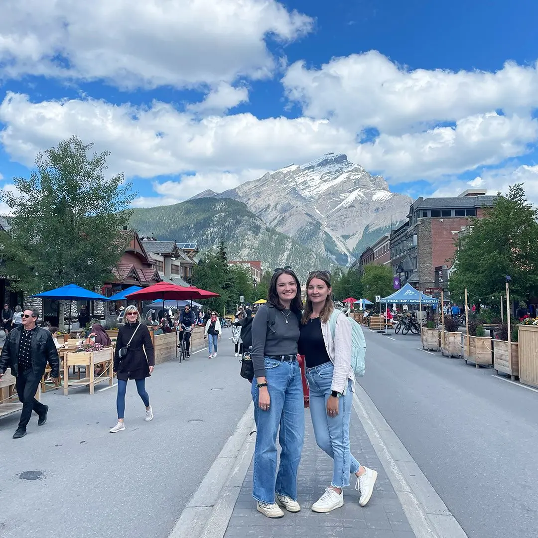 Girls pose on main street with mountain in background