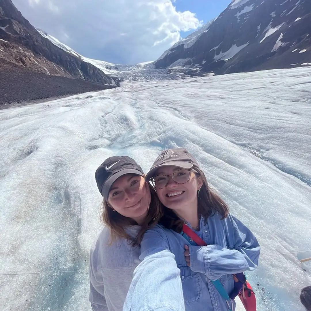 2 girls smile for camera on glacier