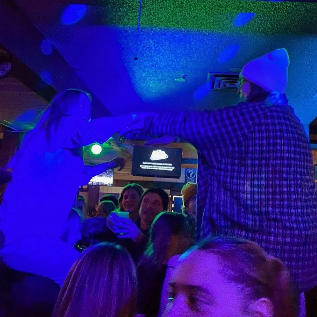 friends on shoulders in nightclub